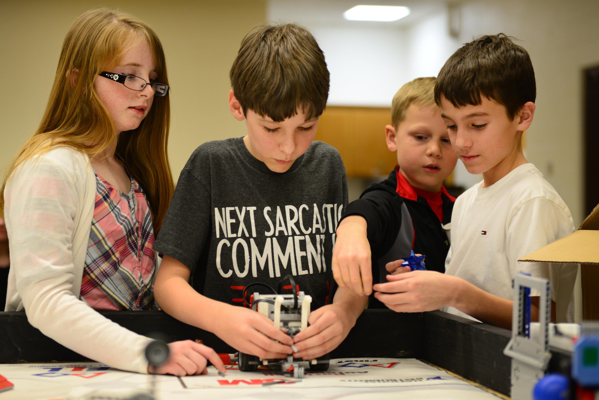 Students from Cannon’s For Inspiration and Recognition of Science and Technology “FIRST”  Lego League teams work together to modify their robot Jan. 29, 2015, at Cannon Air Force Base, N.M. Building and programming robots for competition teaches team members skills like critical thinking, team building, and the application of real-word math and science concepts. (U.S. Air Force photo/Airman 1st Class Shelby Kay-Fantozzi)