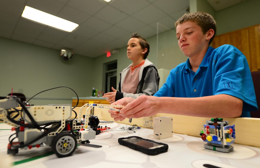 Students from a For Inspiration and Recognition of Science and Technology “FIRST” Lego League team attach new arms to their robot Jan. 27, 2015, at Cannon Air Force Base, N.M. The robot is programmed to score points by interacting with a series of themed obstacles. (U.S. Air Force photo/Airman 1st Class Shelby Kay-Fantozzi)