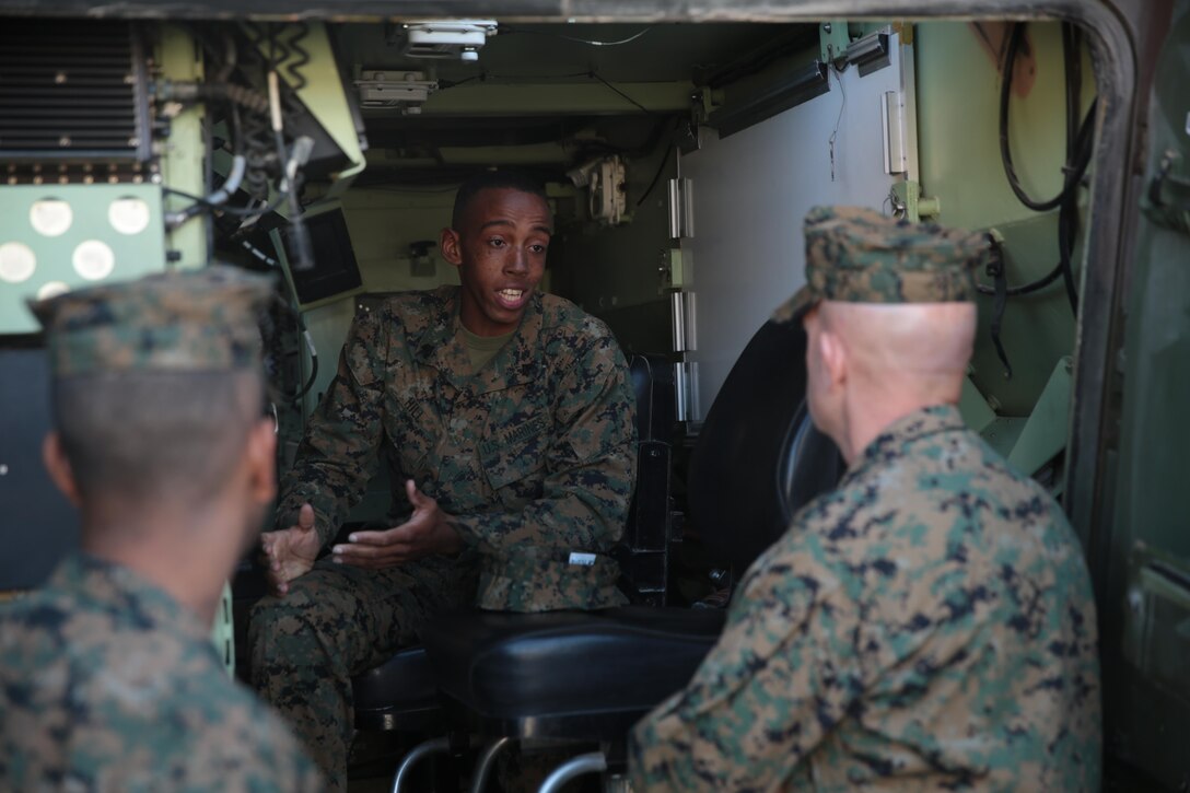 Lt. Gen. David H. Berger, commanding general, I Marine Expeditionary Force listens as Sgt. Milton Hill, field radio operator, 3rd Light Armored Reconnaissance Battalion, native of Knoxville, Tenn., talks to him about the capabilities of the Light Armored Vehicle during his visit to the Combat Center, Feb. 5, 2015. (Official Marine Corps photo by Lance Cpl. Medina Ayala-Lo/Released)