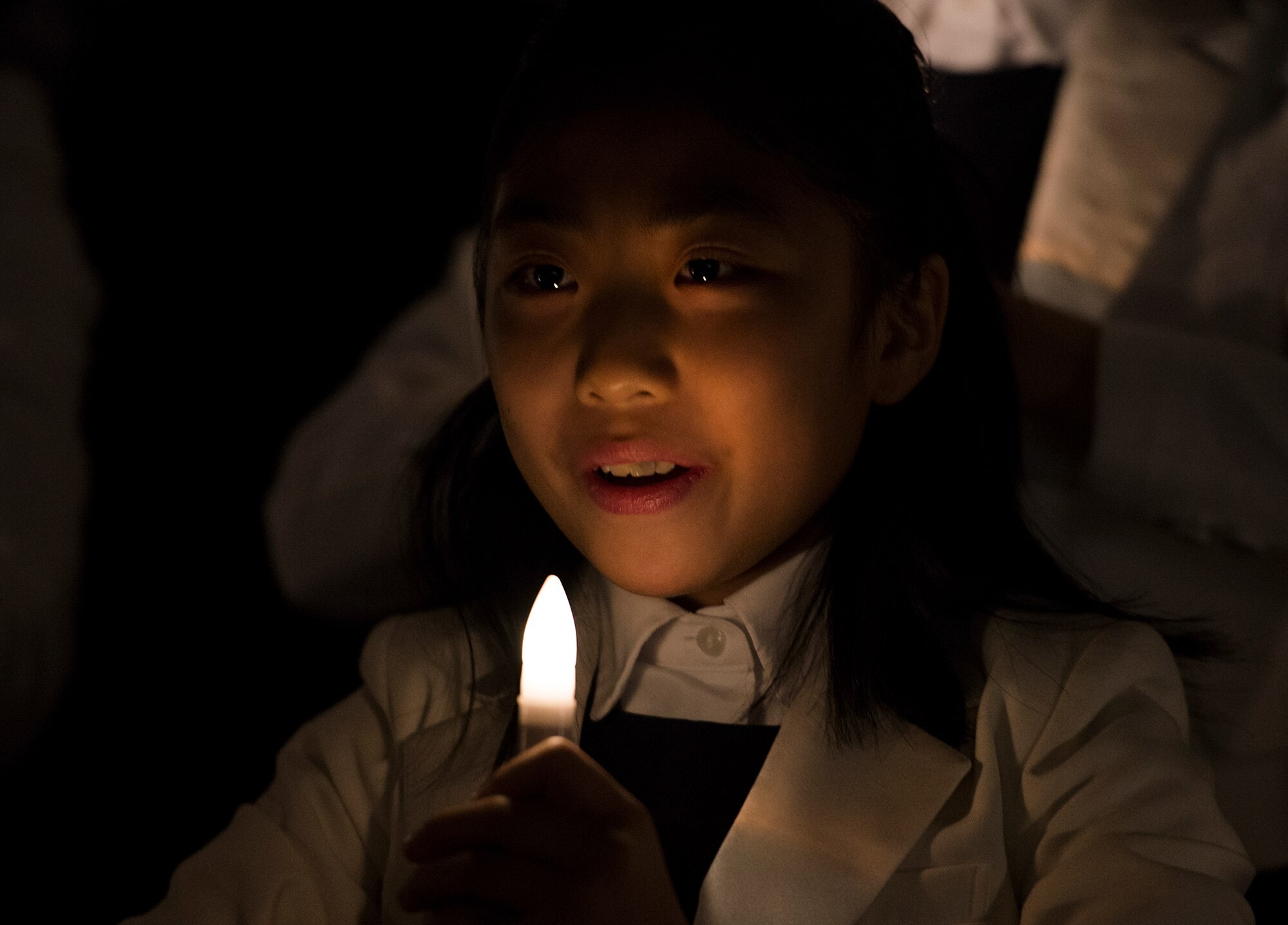 A member of the Far East Broadcasting Company Children's Choir sings during a performance at the National Prayer Breakfast Feb. 12, 2015, at Osan Air Base, Republic of Korea. The NPB is held annually in February in the United States, but the observance at Team Osan included involvement with the host nation Republic of Korea. (U.S. Air Force photo by Staff Sgt. Jake Barreiro/Released)