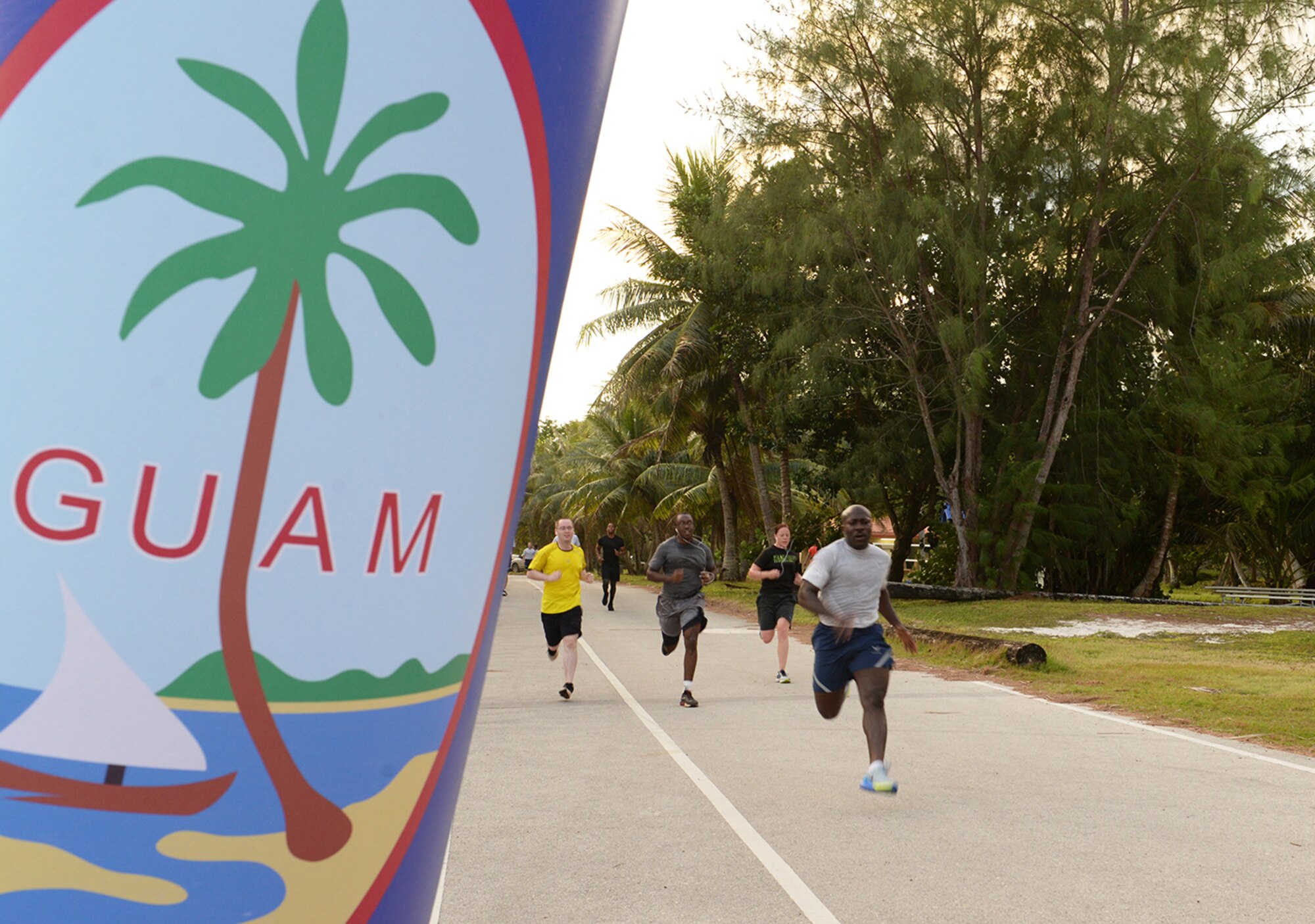 Members of Team Andersen run to the finish line during the I Love to Run 5K hosted by the Coral Reef Fitness Center Feb. 11, 2015 at Tarague Beach at Andersen Air Force base, Guam. The fitness center presented the top four male and top four female finishers with awards after accomplishing the run. (U.S. Air Force photo by Senior Airman Amanda Morris/Released.)