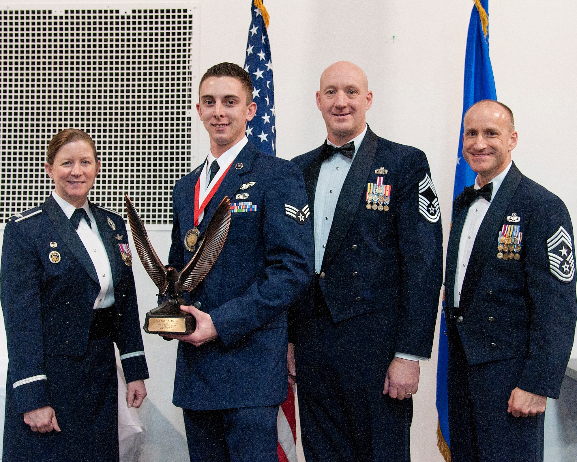 Senior Airman Cody Meyer, 37th Helicopter Squadron special missions aviator, receives the John L. Levitow Award from Col. Tracey Hayes, 90th Missile Wing commander, during the Airman Leadership School graduation Feb. 11, 2015, at F.E. Warren Air Force Base, Wyo. The Levitow Award is the highest achievement for enlisted Airmen enrolled in U.S. Air Force professional military education. There are four levels of PME: ALS, Non-Commissioned Officer Academy, Air Force Senior NCO Academy and Chief Master Sergeant Leadership Course. (U.S. Air Force photo by Senior Airman Jason Wiese)