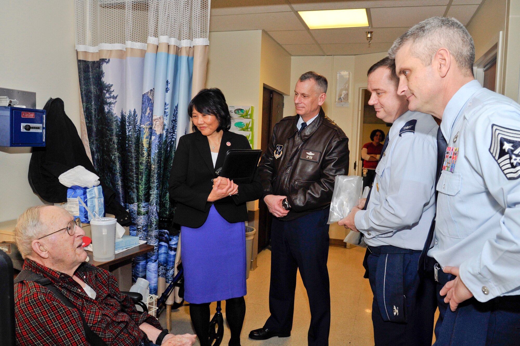 Linda K. Reynolds, director at the Spokane Veteran Medical Center, Col. Daniel J. Swain, 141st Air Refueling Wing commander, Col. Brian McDaniel, 92nd Air Refueling Wing commander, and Chief Master Sgt. Christian Pugh, 92nd ARW command chief, speak with a veteran during the National Salute to Veteran Patients at the Spokane Veteran Medical Center Feb. 11, 2015, in Spokane, Wash. Team Fairchild leaders visited the medical center to pay tribute to the veterans. (U.S. Air Force photo/Airman 1st Class Nicolo J. Daniello)