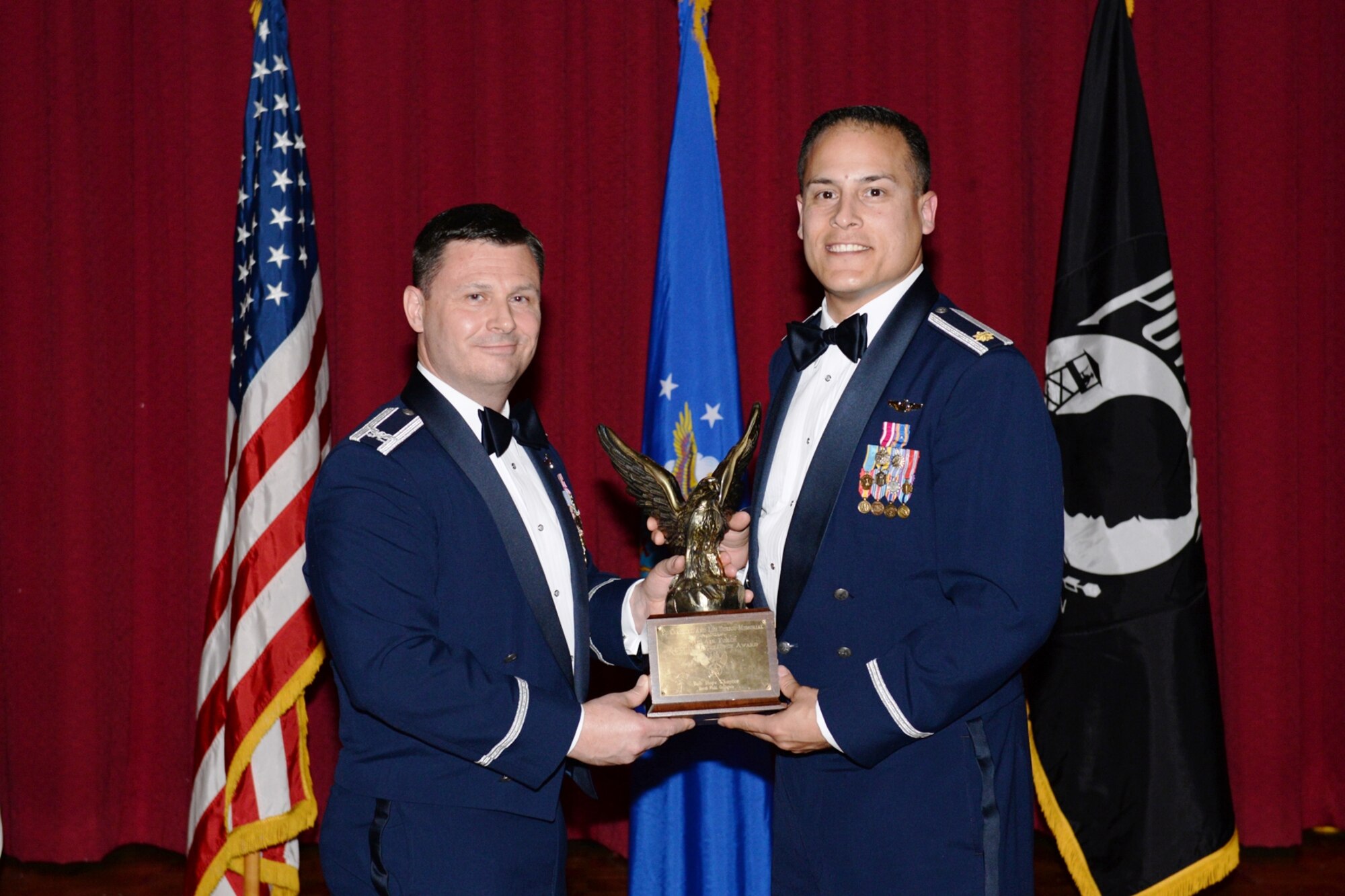 A 68th Airlift Squadron, seven-man crew, “UHAUL-21” was awarded the 4thAir Force Aircrew Excellence Award, Nov 19, 2014 in Riverside, California. Major Federico Mendoza (right) was on hand to receive the award from Col. Lee Merkle, 433rd Operations Group commander during the 433rd Airlift Wing Awards Banquet, held Feb. 7, 2015 at the Gateway Club, Joint Base San Antonio, Texas. (U.S. Air Force photo/Senior Airman Krystal Jeffers) 
