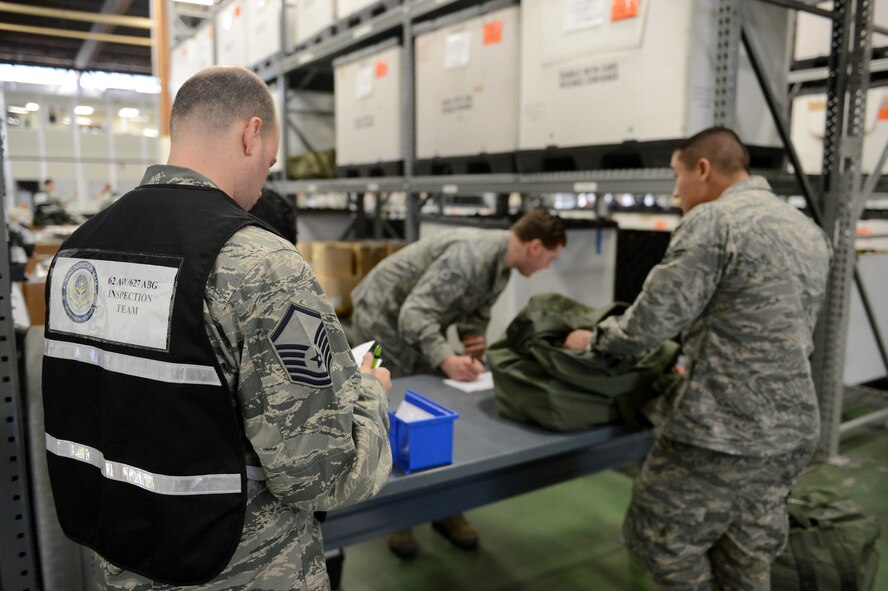Master Sgt. Jay Speck(left), 627th Logistics Readiness Squadron NCO in charge of customer service, evaluates deployment processing line procedures Feb. 3, 2015, during Exercise SNAPSHOT at Joint Base Lewis-McChord, Wash. Members of the 62nd Airlift Wing, 446th AW and 627th Air Base Group were required to execute direct delivery combat operations. (U.S. Air Force photo/Airman 1st Class Keoni Chavarria)