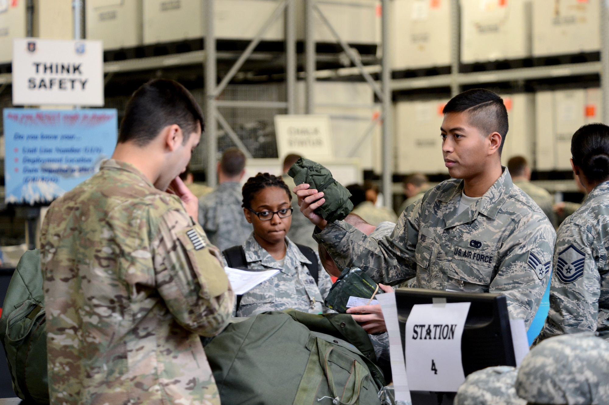 Senior Airman Austin Kou (right), 627th Logistics Readiness Squadron individual protection equipment technician, shows Airman 1st Class Cory McClellan, 627th Civil Engineer Squadron explosive ordnance disposal technician, a piece of equipment Feb. 3, 2015, during Exercise SNAPSHOT at Joint Base Lewis-McChord, Wash. The exercise tested JBLM’s capabilities and readiness for a short-notice deployment. (U.S. Air Force photo/Airman 1st Class Keoni Chavarria)