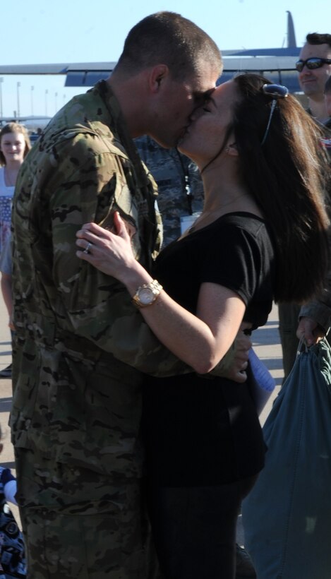 U.S. Air Force Capt. Beau Tresemer, 39th Airlift Squadron, embraces and kisses his wife Feb. 4, 2015, at Dyess Air Force Base, Texas. Capt. Tresemer deployed for more than three months to Dakar, Sengal, in support of Operation United Assistance, where Dyess Airmen transported personnel, medical supplies and equipment in order to enable the training of healthcare providers and construction of Ebola Treatment Units. (U.S. Air Force photo by Senior Airman Shannon Hall/Released)