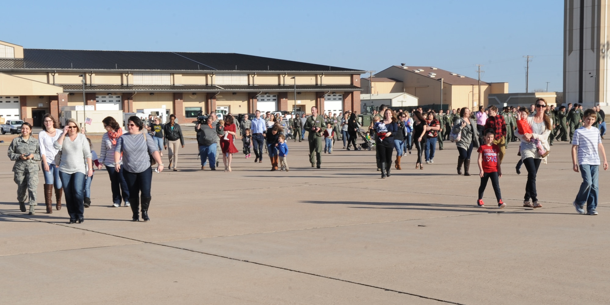 Family, friends and co-workers step onto the flightline to greet Airmen returning from a deployment Feb. 4, 2015, at Dyess Air Force Base, Texas. Airmen from the 317th Airlift Group and 7th Bomb Wing deployed to Dakar, Senegal, on Oct. 29, 2014, in support of Operation United Assistance. (U.S. Air Force photo by Senior Airman Shannon Hall/Released)