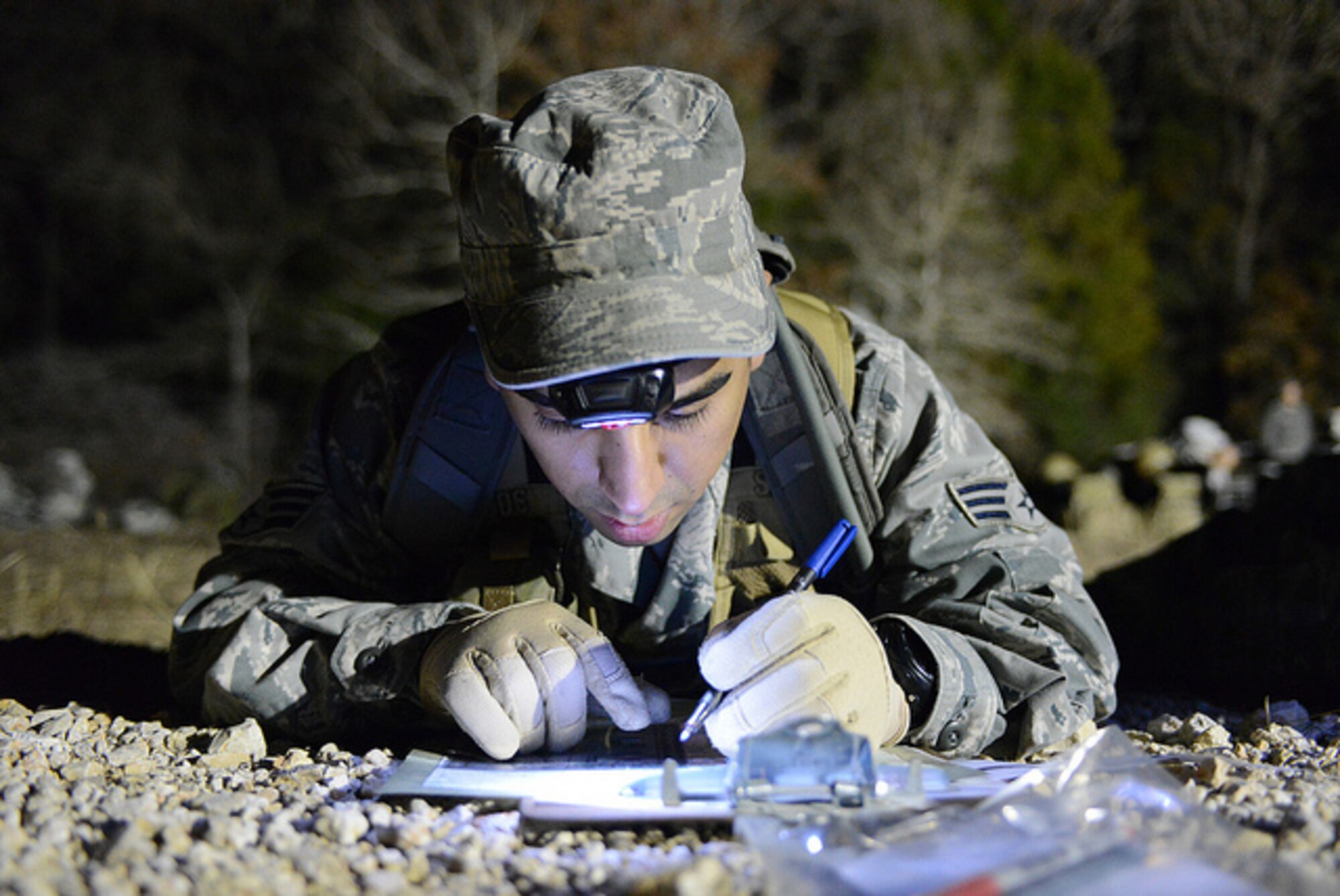 U.S. Air Force Senior Airman Michael Renteria, 147th Air Support Operations Squadron, Texas Air National Guard, plots the points on his map during the twilight land-navigation course at the 2015 Best Warrior Competition at Camp Swift, Texas, Feb. 7, 2015. The competition determines the best of the best warrior amongst Army and Air National Guardsmen. (photo by Master Sgt. Charles Hatton/released)