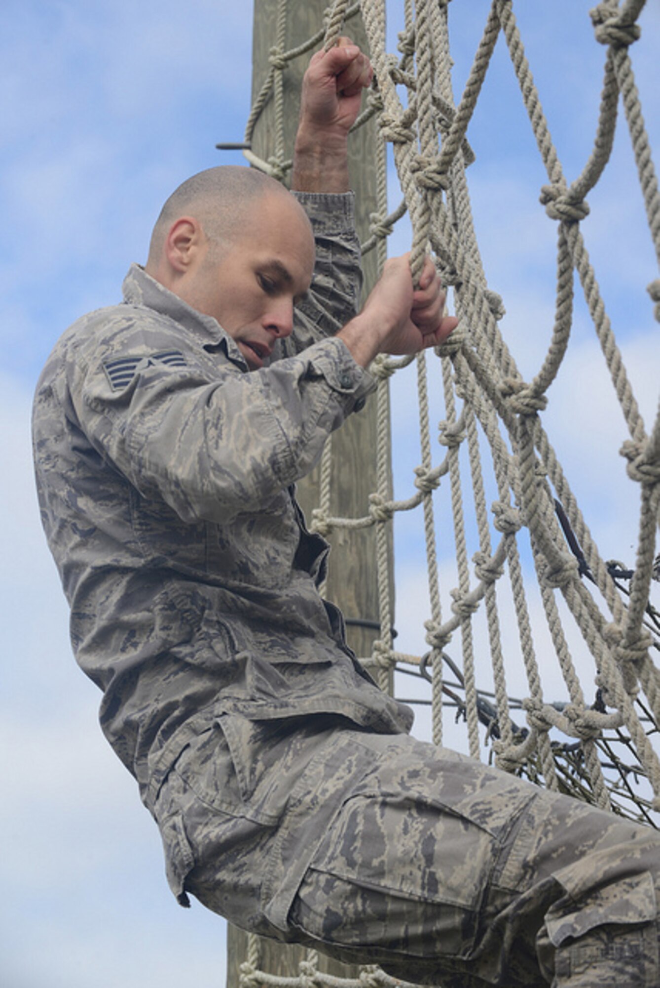 U.S. Air Force Staff Sgt. Steven Hein, 136th Security Forces Squadron, Texas Air National Guard, climbs down the cargo-climbing nets, one of the more difficult obstacles during the 2015 Best Warrior Competition at Camp Swift, Texas, Feb. 7, 2015. The competition determines the best of the best warrior amongst Army and Air National Guardsmen. (photo by Master Sgt. Charles Hatton/released)