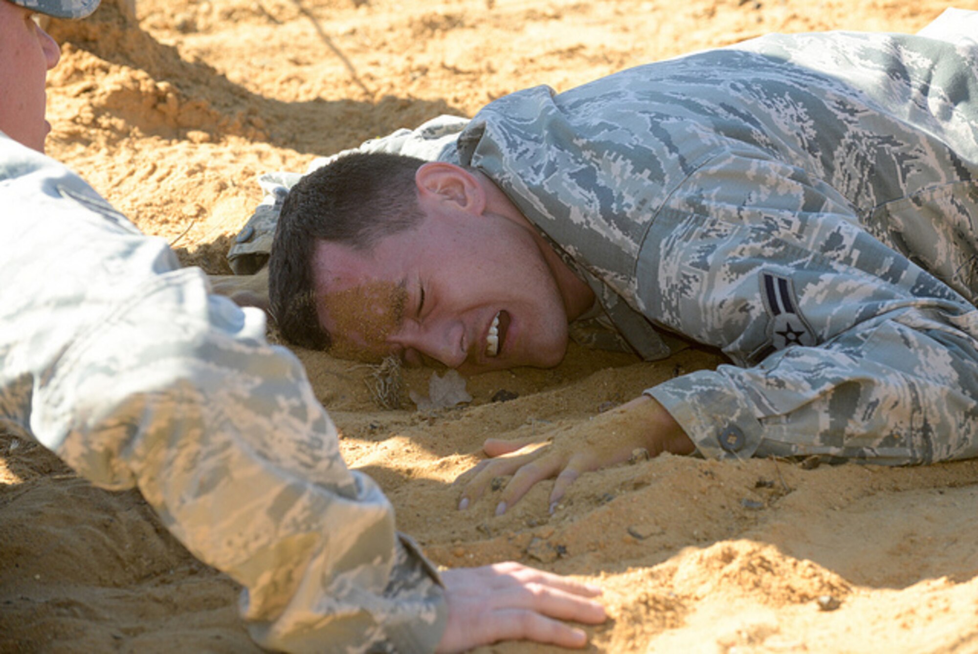 Airman 1st Class John Williams, 136th Maintenance Squadron, Texas Air National Guard, inches his way through the barbwire obstacle during the 2015 Best Warrior Competition at Camp Swift, Texas, Feb. 7, 2015. The competition determines the best of the best warrior amongst Army and Air National Guardsmen. (photo by Master Sgt. Charles Hatton/released)