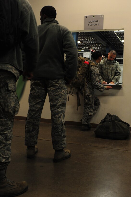 U.S. Air Force Staff Sgt. Jose Diaz, 633rd Logistics Readiness Squadron supply technician, distributes mobility bag items to 633rd Air Base Wing Airmen during a deployment exercise Feb. 10, 2015, at Langley Air Force Base, Va.  The exercise tested mobility response times and preparedness to ensure optimal global mission support. (U.S. Air Force photo by Staff Sgt. Natasha Stannard)