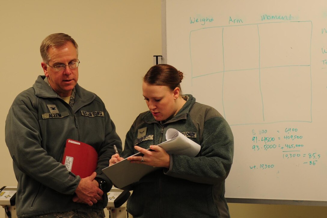 U.S. Air Force Airman 1st Class Jamilyn Scott, 633rd Logistics Readiness Squadron passenger travel clerk, checks Col. John J. Allen, 633rd Air Base Wing commander, into the predeployment line during a deployment exercise Feb. 10, 2015, at Langley Air Force Base, Va.  The commander and the Wing command chief took part in the exercise alongside their fellow Airmen. (U.S. Air Force photo by Staff Sgt. Natasha Stannard)