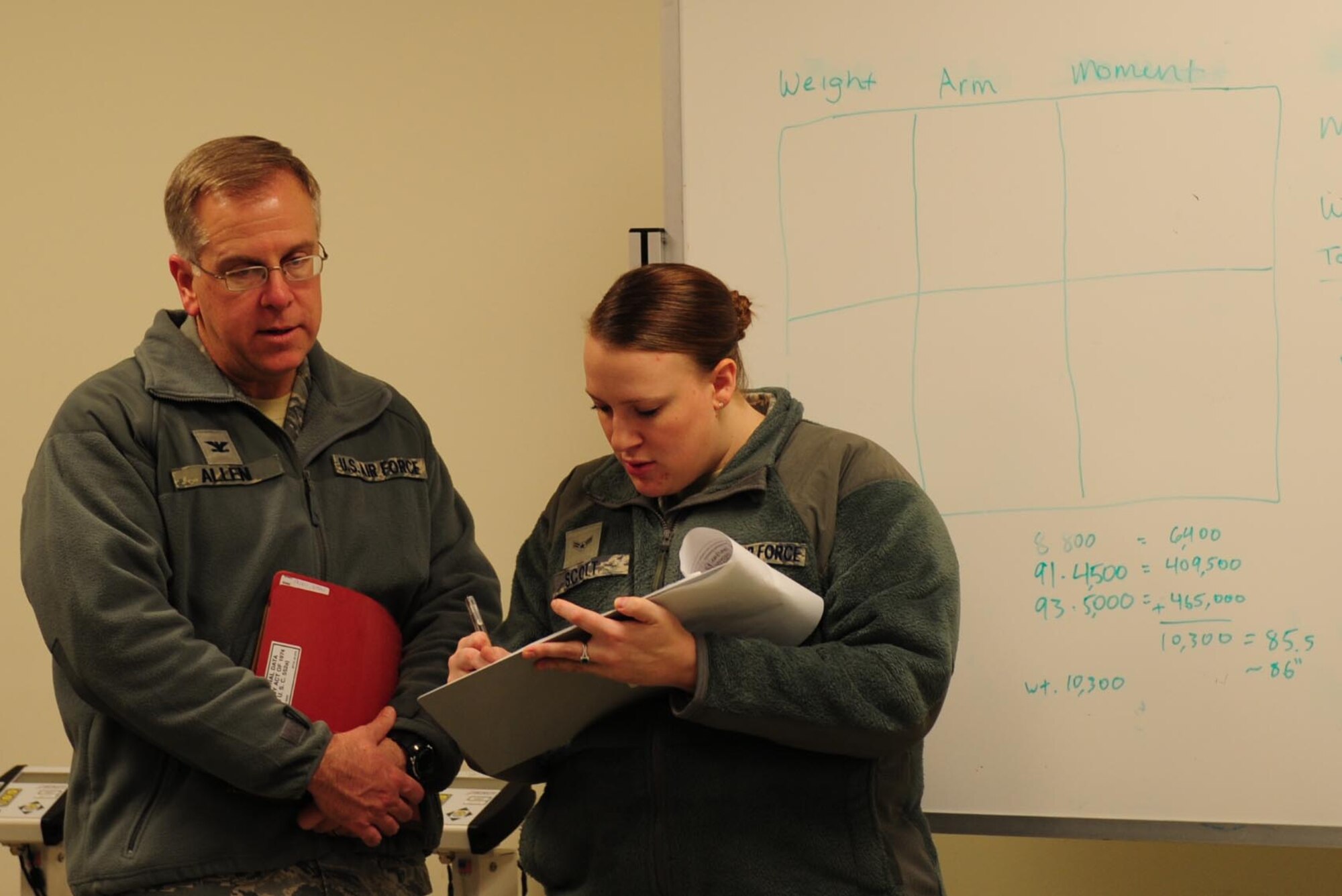 U.S. Air Force Airman 1st Class Jamilyn Scott, 633rd Logistics Readiness Squadron passenger travel clerk, checks Col. John J. Allen, 633rd Air Base Wing commander, into the predeployment line during a deployment exercise Feb. 10, 2015, at Langley Air Force Base, Va.  The commander and the Wing command chief took part in the exercise alongside their fellow Airmen. (U.S. Air Force photo by Staff Sgt. Natasha Stannard)