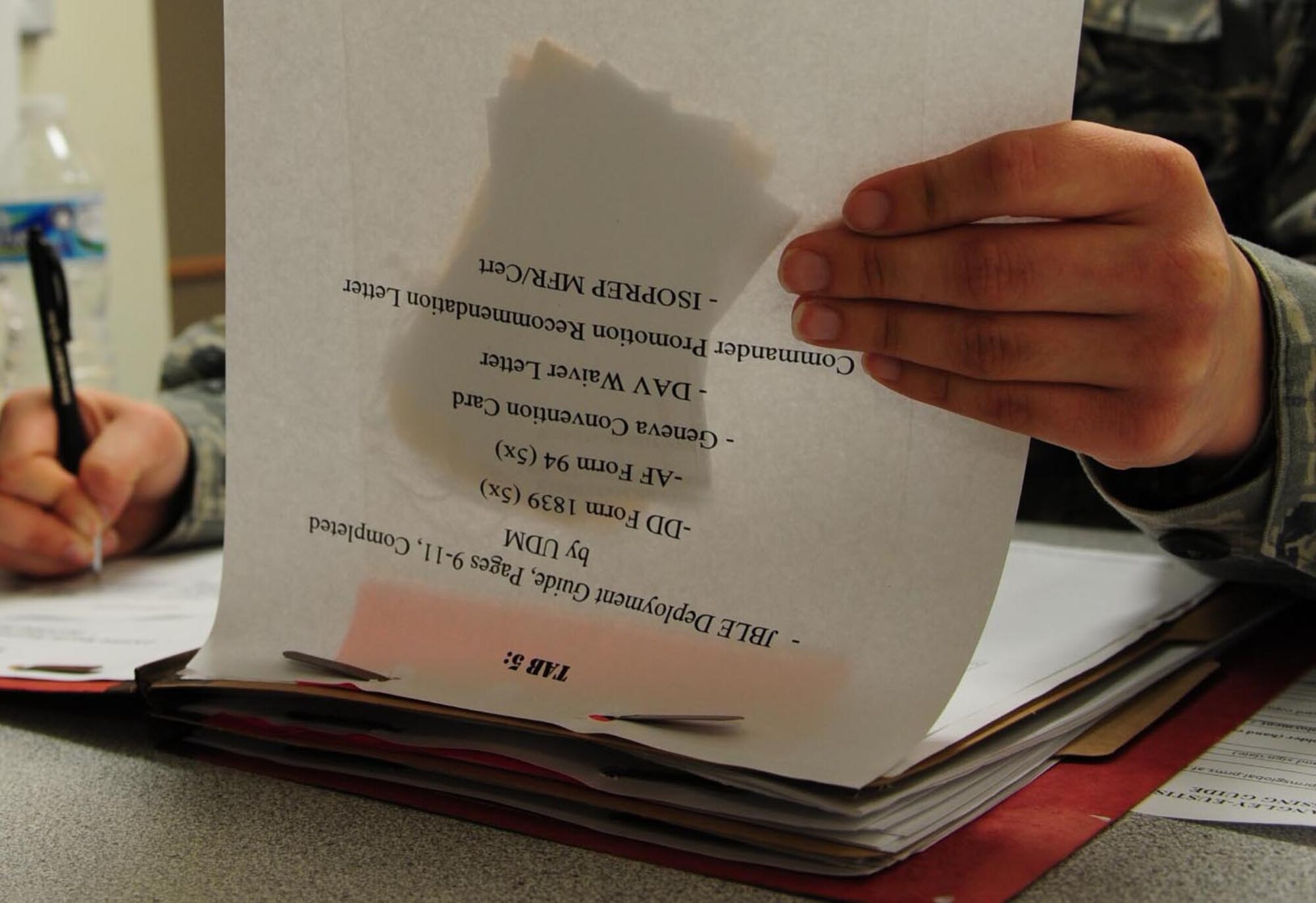 U.S. Air Force Senior Airman Jennifer Murphy, 633rd Force Support Squadron force management technician, checks required mobility folder items during a deployment exercise Feb. 10, 2015, at Langley Air Force Base, Va.  The week-long exercise involved preparing mobility items for a short-notice deployment, ensuring readiness for real-world events. (U.S. Air Force photo by Staff Sgt. Natasha Stannard)