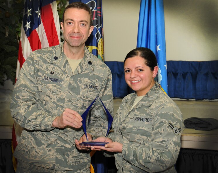 Lt. Col. Geno Rapone, 270th Engineering and Installation Squadron commander, hands an award to Airman 1st Class Angela Otto, 270th EIS administrative assistant, as the 111th Attack Wing recognized five 2014 Annual Award recipients during a ceremony held here Feb. 8, 2015 at the headquarters building, Horsham Air Guard Station , Pa. The categories in which the Guardsmen competed were Airmen, Noncommissioned Officer, First Sergeant, Senior NCO and Company Grade Officer of the Year. The winners each received and plaque and certificate to recognize their achievements.(U.S. Air National Guard photo by Staff Sgt. Michael Stauffer/Released)