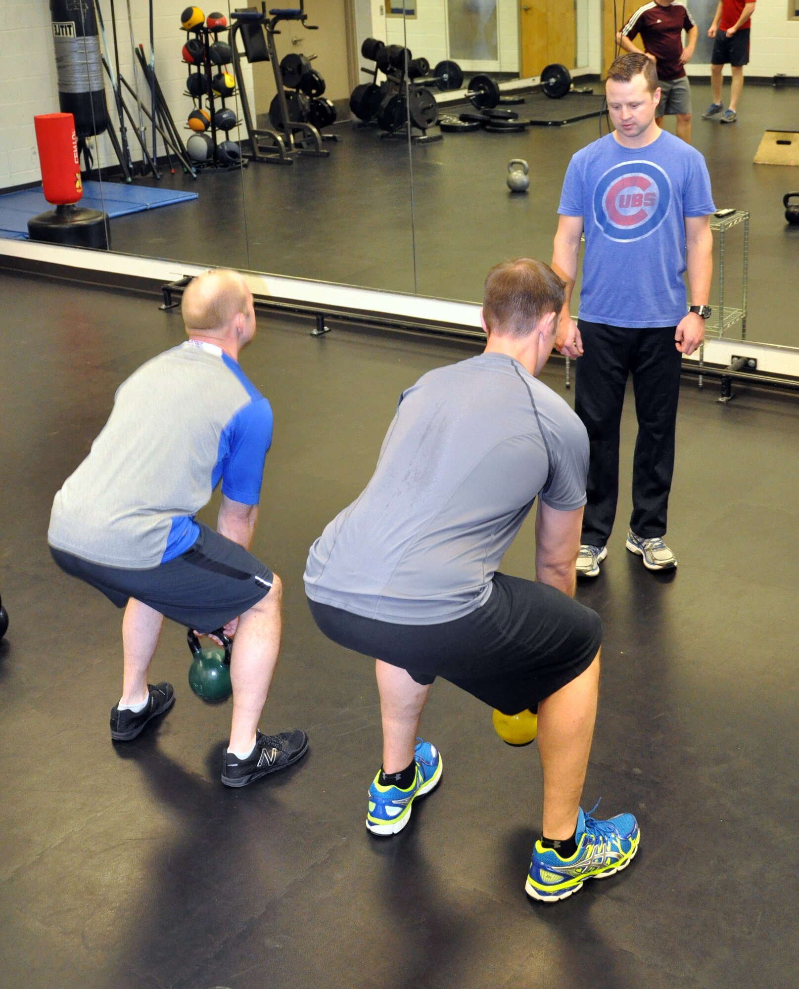 Tech. Sgt. Daniel Mills, a refueling boom operator assigned to the 18th Air Refueling Squadron, 931st Air Refueling Group, instructs unit members performing kettlebell squats during a group workout at the base fitness center, Feb. 4, 2015. Mills leads daily workouts for unit members to improve overall fitness and help Airmen stay "fit to fight." (U.S. Air Force photo by Capt. Zach Anderson)