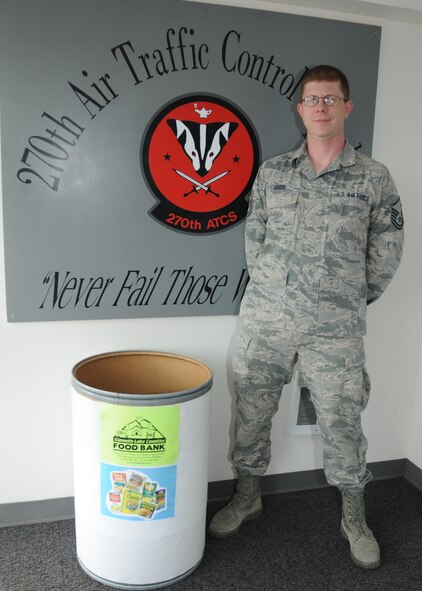Oregon Air National Guard Master Sgt. Michael Moore, 270th Air Traffic Control Squadron, stands next to a food donation bin for the Governor's State Employees Food Drive, at Kingsley Field, Ore Feb. 11, 2015. Moore is spearheading this year’s collection efforts for Kingsley Field; since its inception in 1982 by Governor Atiyeh the food drive has collected more than 70 million pounds of food. (U.S. Air National Guard photo by Tech. Sgt. Daniel J. Condit/Released)