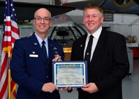 Col. Eric W. Brandes, 512th Maintenance Group commander, presents a certificate of induction to Kevin Phillipson, WJ Publishing owner, as part of the Team Dover Honorary Commander Induction Ceremony Feb. 7, 2015, at the Air Mobility Command Museum. The Honorary Commander Program began in 1992 at Dover Air Force Base, Del.,to foster relationships between civic and military leaders. (U.S. Air Force photo/Airman 1st Class William Johnson)