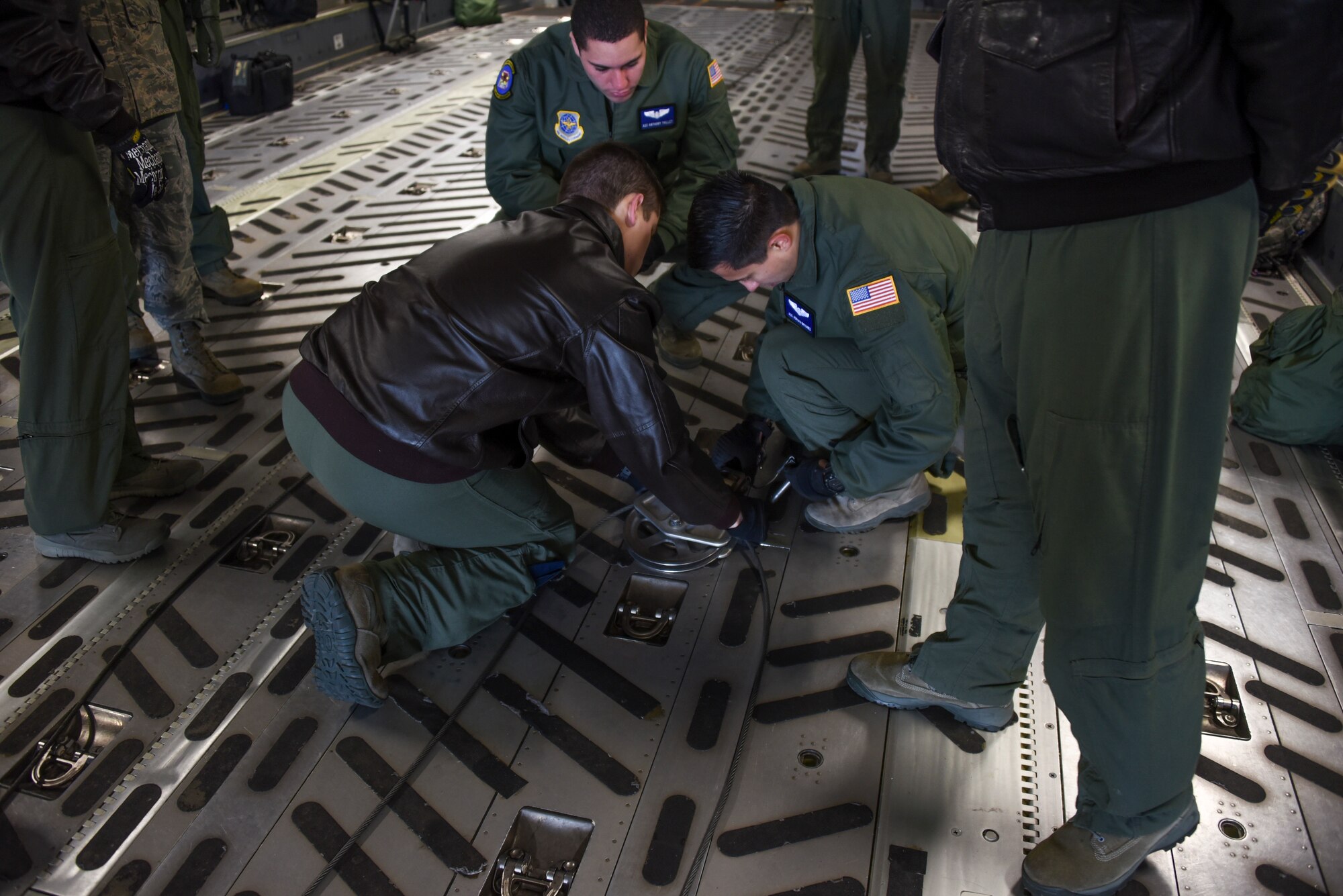 Load masters from the 305th Air Mobility Wing, the 514th Air Mobility Wing Reservists and the 621st Contingency Response Wing secure the winch system in place on a C-17 Globemaster III at Joint Base McGuire-Dix-Lakehurst, N.J., Jan. 23, 2015. The load masters were taught several ways to hook up the winch to load cargo onto the aircraft. (U.S. Air Force photo by Airman 1st Class Tara A. Williamson/Released)
