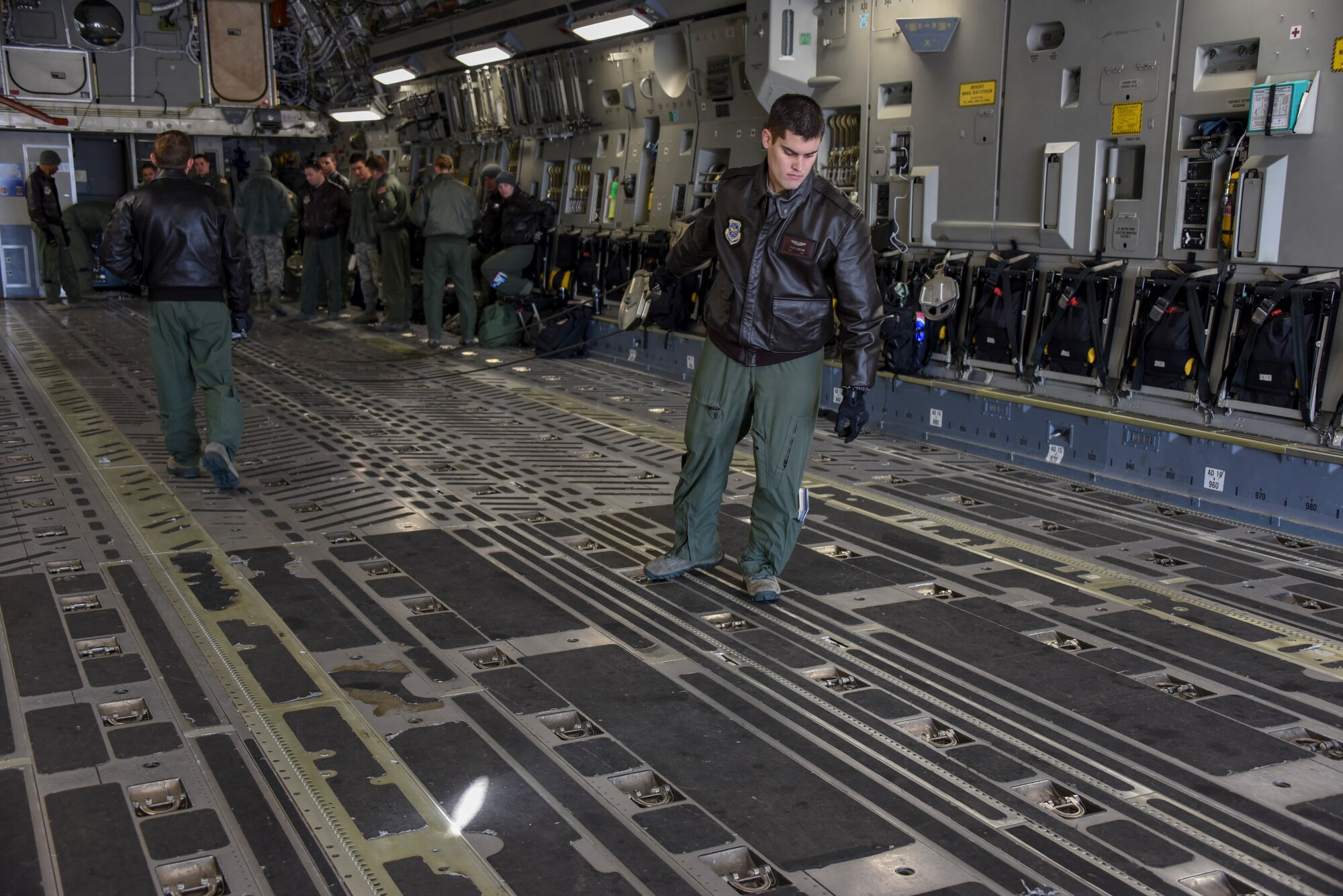 Senior Airman Tyler Cameron, 6th Airlift Squadron load master, pulls the winch taught on a C-17 Globemaster III in order to secure a cargo trailer during training at Joint Base McGuire-Dix-Lakehurst, N.J., Jan. 23, 2015. Load masters from the 305th Air Mobility Wing, the 514th Air Mobility Wing Reservists and the 621st Contingency Response Wing came together to receive hands-on training on the hazardous winch system. (U.S. Air Force photo by Airman 1st Class Tara A. Williamson/Released)