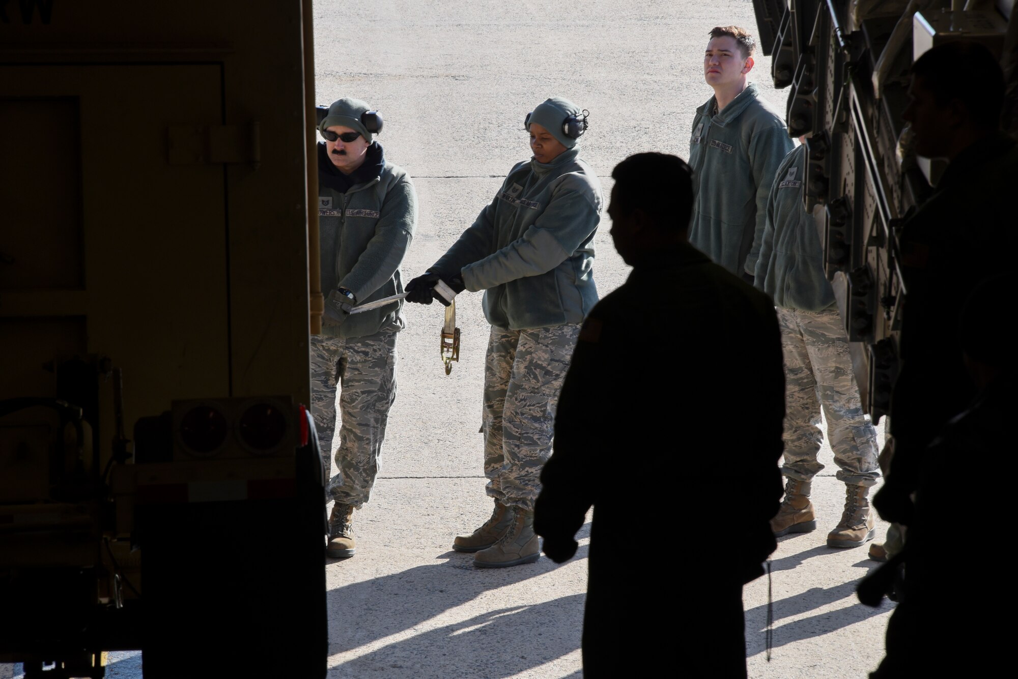 Load masters from the 305th Air Mobility Wing, the 514th Air Mobility Wing Reservists and the 621st Contingency Response Wing steady a trailer while using the winch system on a C-17 Globemaster III at Joint Base McGuire-Dix-Lakehurst, N.J., Jan. 23, 2015. The load masters were taught several ways to hook up the winch to load cargo onto the aircraft. (U.S. Air Force photo by Airman 1st Class Tara A. Williamson/Released)