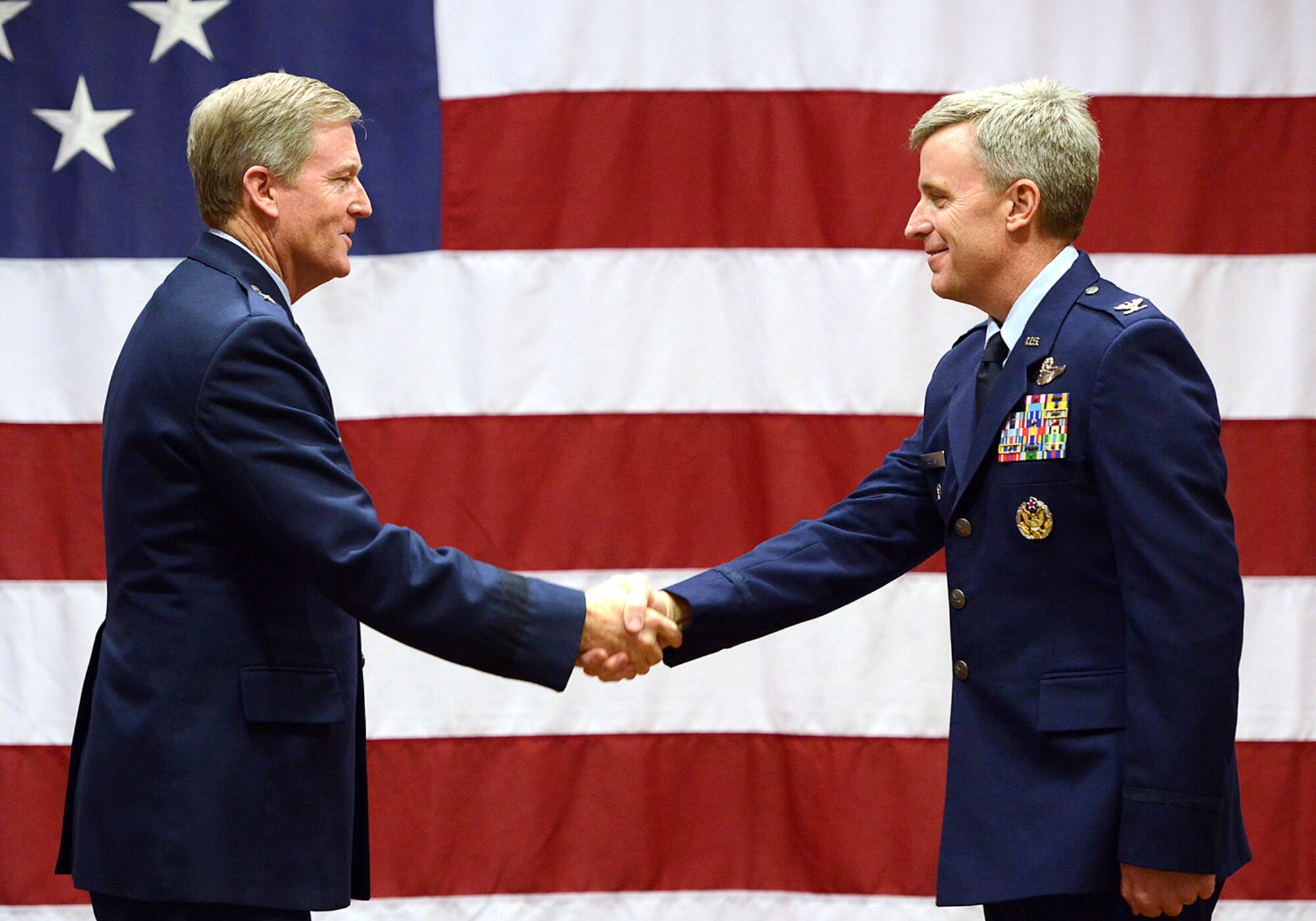 Oklahoma Assistant Adjutant General Air, Brig. Gen. Greg Ferguson congratulates Col. Rick Poplin after promoting him to the rank of colonel during a pinning ceremony Feb. 8, 2015, Tulsa Air National Guard base, Tulsa, Okla.  The pinning ceremony followed a change of command where Poplin assumed command of the 138th Operation Group during the wing's February unit training assembly.  (U.S. National Guard photo by Master Sgt.  Mark A. Moore/Released)