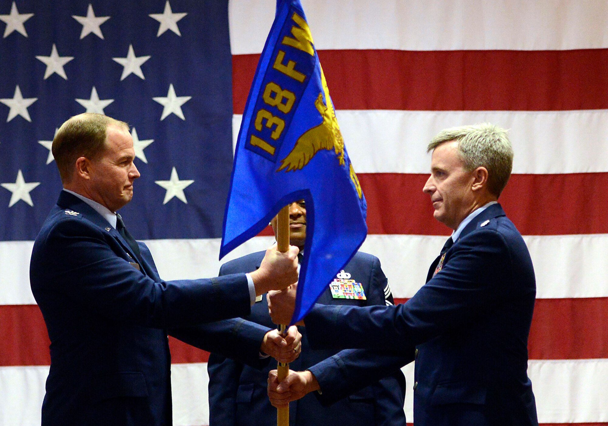 Col. Rick Poplin accepts the 138th Operations Group (OG) guidon from Col. David B. Burgy, 138th Fighter Wing commander, during a change of command ceremony for the 138th OG, Feb. 8, 2015, Tulsa Air National Guard base, Tulsa, Okla.  The ceremony was officiated by Burgy and was held in the aerospace dining facility during the wing's February unit training assembly.  (U.S. National Guard photo by Master Sgt.  Mark A. Moore/Released)