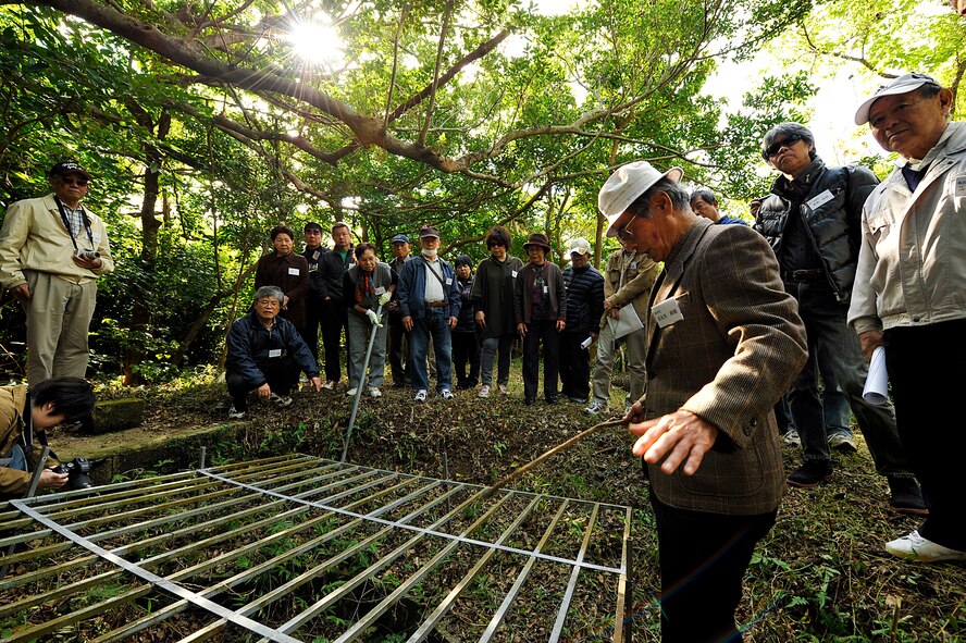 Members from the Chatan Hometown Association look inside of the draw well, Menu-ka, during their sacred site visit on Kadena Air Base, Okinawa, Japan, Feb. 11, 2015. This draw well, which was equipped with a pulley block and a well bucket, was constructed near the central area of the village around the year 1913. This well was almost completely demolished during the Battle of Okinawa, but some worshippers still pay a visit to the well even today. (U.S. Air Force photo by Naoto Anazawa)

