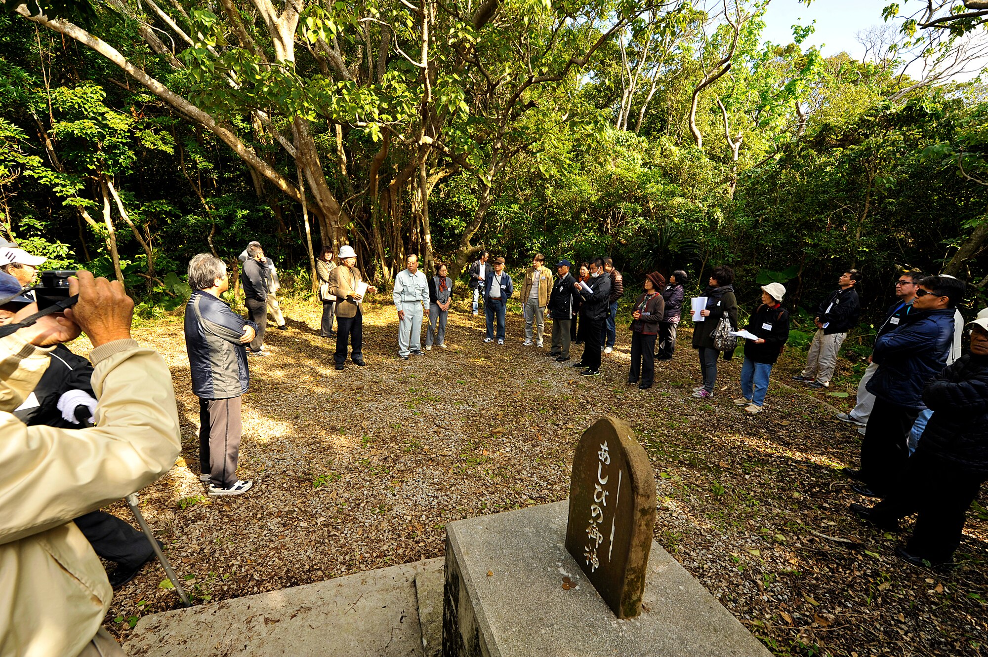 Members from the Chatan Hometown Association visit the Ashibi-na (playing square) on Kadena Air Base, Okinawa, Japan, Feb. 11, 2015. The tour was conducted to allow Chatan Hometown Association members to visit the places their ancestors used before World War II, such as gathering and worship sites, and water wells. (U.S. Air Force photo by Naoto Anazawa)