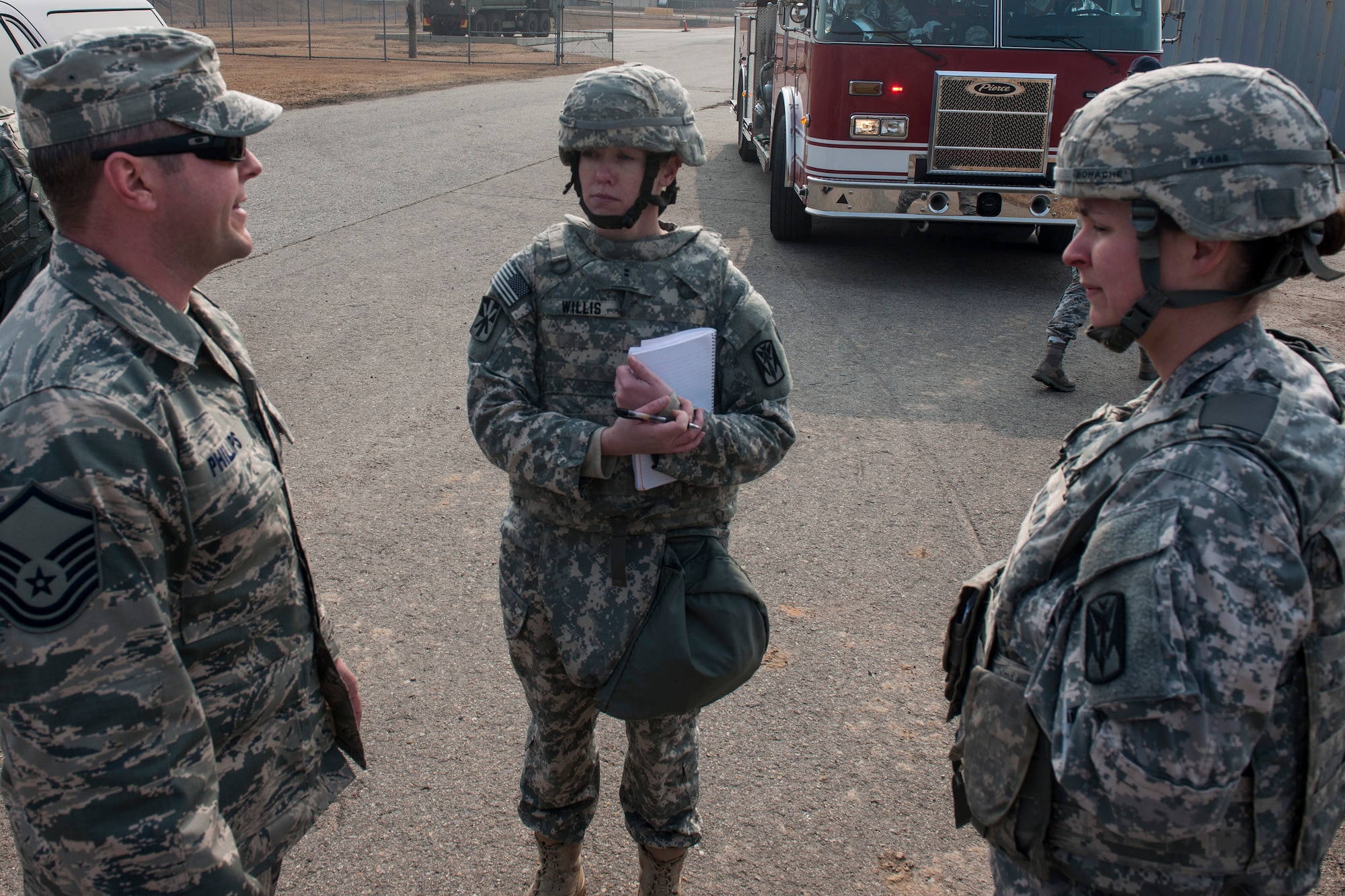 Master Sgt. Jeremy Phillips, 8th Civil Engineer Squadron Explosive Ordnance Disposal team leader (left), Chief Warrant Officer 2 Jessica Willis, Alpha Battery, 2nd Battalion, 1st Air Defense Artillery air and missile defense tactician (center), and Capt. Jessica Bohache, A/2-1 ADA BN battery commander, discuss EOD’s response to a simulated dropped patriot missile canister during the battalion’s quarterly field training exercise at Kunsan Air Base, Republic of Korea, Feb. 11, 2015. Incorporating the Air Force’s response into the missile inject presented a new training opportunity for not only soldiers directly involved, but also for the Wolf Pack. (U.S. Air Force photo by Senior Airman Katrina Heikkinen/Released)