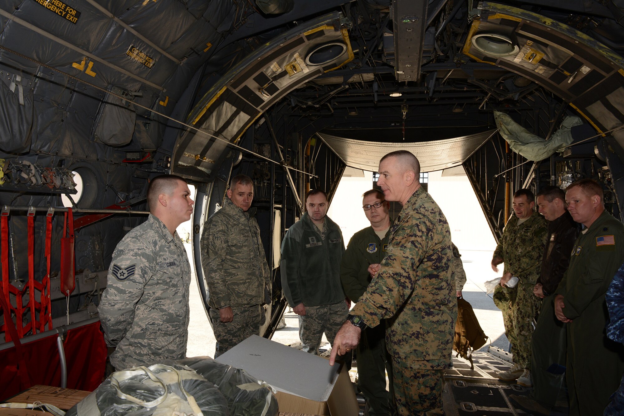Staff Sgt. Joshua Correa, combat mobility flight supervisor, briefs Marine Corps Sgt. Maj. Bryan Battaglia, senior enlisted advisor to the chairman of the Joint Chiefs of Staff, aboard a C-130 Hercules at Yokota Air Base, Japan, Feb. 11, 2015. Correa explained how the low-cost, low-altitude pallets are created for various missions. (U.S. Air Force photo by Senior Airman Desiree Economides/Released)
