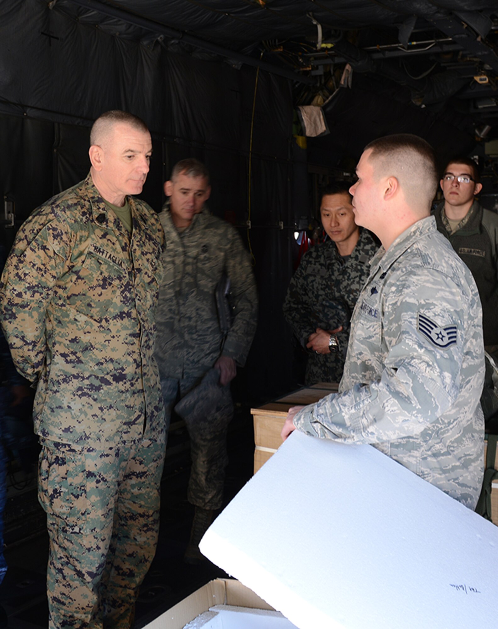 The senior enlisted advisor to the chairman of the Joint Chiefs of Staff, Marine Corps Sgt. Maj. Bryan Battaglia, asks Staff Sgt. Joshua Correa, combat mobility flight supervisor, a question about the low-cost, low-altitude pallets used for Operation Christmas Drop, Feb. 11, 2015, at Yokota Air Base, Japan. Operation Christmas Drop is the world’s longest running airdrop mission, which Yokota participates in every year. (U.S. Air Force photo by Senior Airman Desiree Economides/Released)