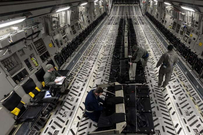 Senior Airman David Carlson (left), Staff Sgt. Ari Schlesinger, Airman Daniel Giulian and Tech. Sgt Carlos Santiago, crew chiefs with the 437th Aircraft Maintenance Squadron, reconfigure a C-17 Globemaster III after its flight at Joint Base Charleston, S.C., Feb. 11, 2015. The crew chiefs, considered "jacks of all trades," ensure maintenance work on an aircraft is accomplished and done correctly--24 hours a day, seven days a week. (U.S. Air Force photo/Tech. Sgt. Renae Pittman)