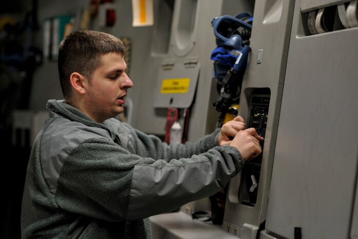 Senior Airman James Miles, a crew chief with the 437th Aircraft Maintenance Squadron, inspects the aerial delivery system on a C-17 Globemaster III at Joint Base Charleston, S.C., Feb. 11, 2015. Miles, who currently works the mid shift, checked pressure in the rail system and the lock arm release functions to ensure the plane was prepared for its drop mission the next day. (U.S. Air Force photo/Tech. Sgt. Renae Pittman)