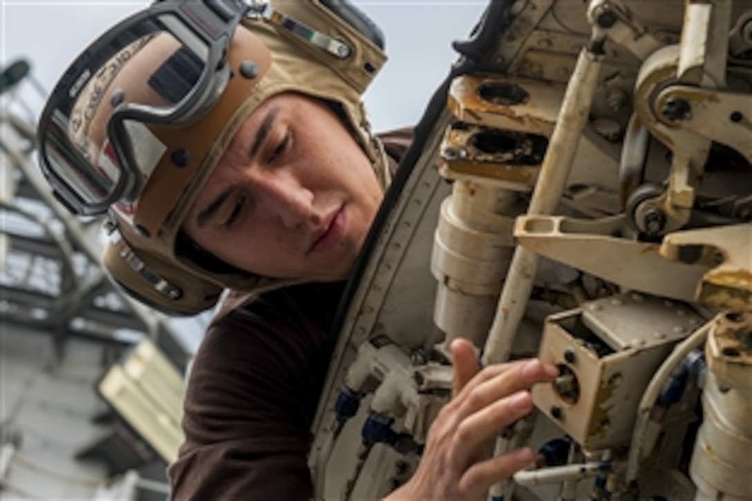U.S. Navy Airman Arturo Gourentchik performs maintenance on a E-2C Hawkeye on the flight deck of the aircraft carrier USS Carl Vinson in the Persian Gulf, Feb. 8, 2015. The Carl Vinson is deployed in the U.S. 5th Fleet area of responsibility supporting Operation Inherent Resolve. Gourentchik is assigned to Carrier Airborne Early Warning Squadron.