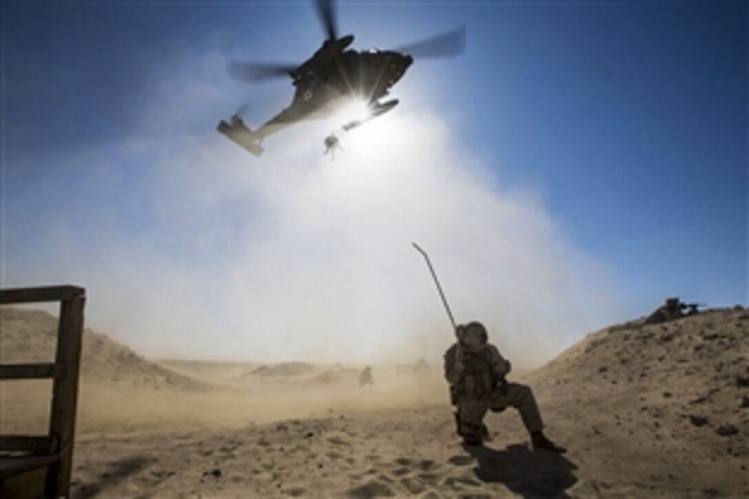 U.S. Navy Seaman Patrick McCrimmon communicates with pilots from a U.S. Army UH-60 Black Hawk as it airlifts simulated casualties during medical evacuation training at Udairi Range, Kuwait, Feb. 5, 2015. McCrimmon is a hospital corpsman assigned to Bravo Company, Battalion Landing Team 3rd Battalion, 6th Marine Regiment, 24th Marine Expeditionary Unit.
