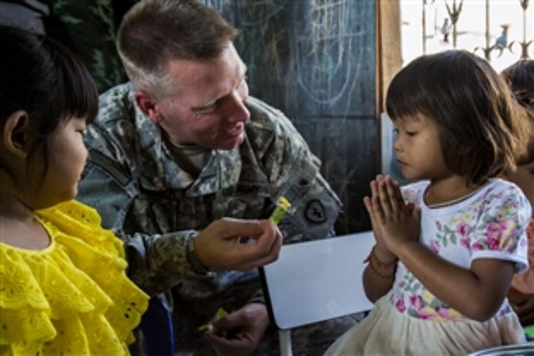 U.S. Army Capt. Ryan Mortensen visits with children of The Middle Mosque of Lop Buri during Cobra Gold 15 in Lop Buri, Thailand, Feb. 3, 2015. Mortensen is a chaplain assigned to the 25th Infantry Division's 1st Battalion, 27th Infantry Regiment. 
