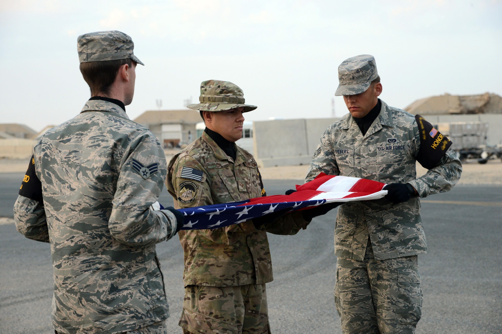 SOUTHWEST ASIA - Airmen from the 386th Air Expeiditionary Wing Honor Guard perform a flag folding ceremony during a memorial for the crew of Spirit 03 here Jan. 31, 2015. All 14 crew members were killed when Spirit 03 was shot down on Jan. 31, 1991.
