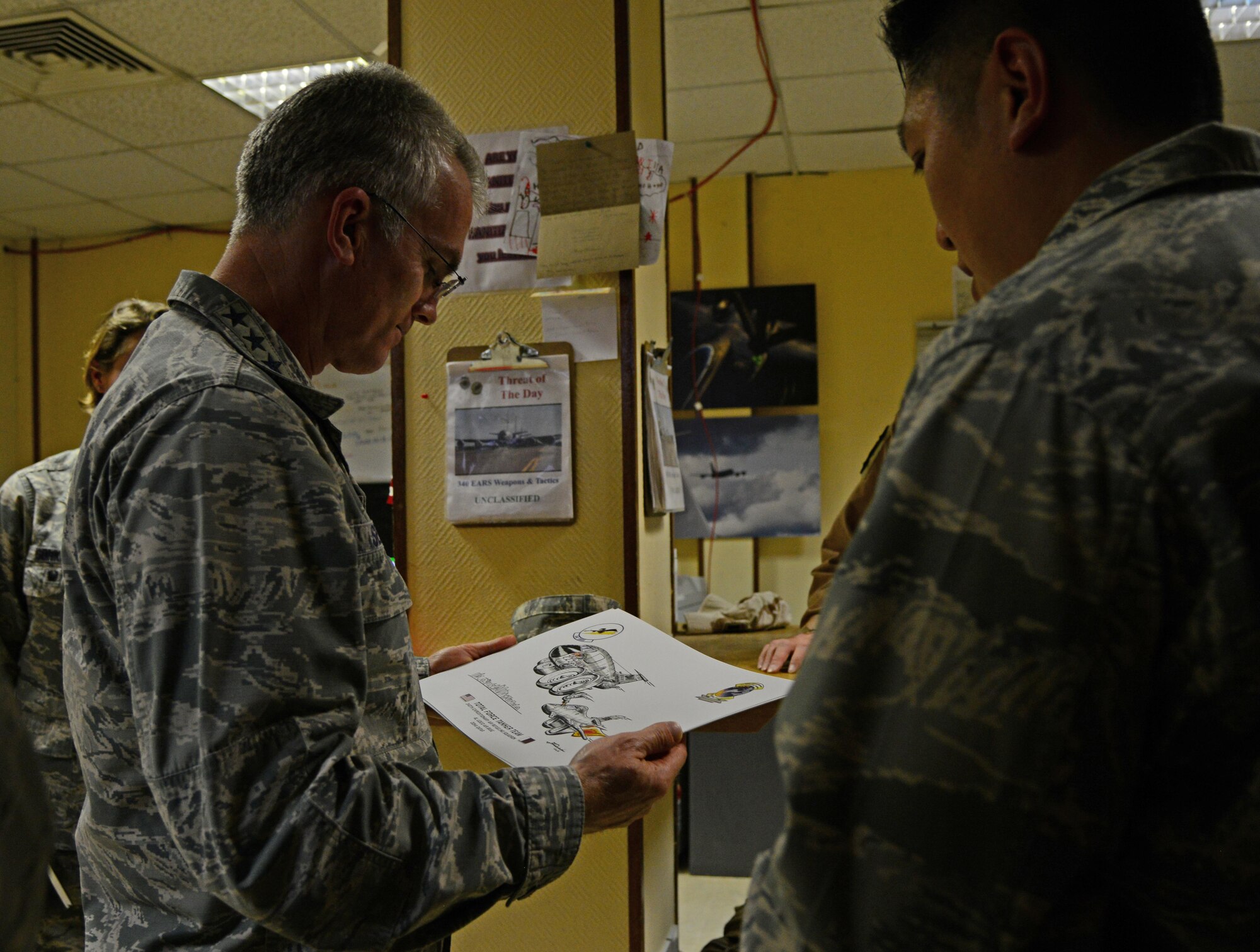 U.S. Air Force Gen. Paul Selva, left, commander of U.S. Transportation Command, looks at a gift from the 340th Expeditionary Air Refueling Squadron, during his visit, Jan. 31, 2015, at Al Udeid Air Base, Qatar. Selva visited several squadrons on base where he met with Airmen and thanked them for what they contribute to the mission. USTRANSCOM is the single manager of global air, land and sea transportation for the Department of Defense.  (U.S. Air Force photo by Senior Airman Kia Atkins)