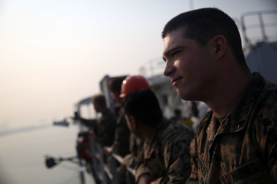 Lance Cpl. Jackson C. Chandler stands on deck as the Maritime Prepositioning Force ship, USNS Pililaau, arrives at the port in Laem Chabang, Thailand, from Guam Feb. 8 after eight days at sea. Their mission is to prepare and offload equipment from ship to shore in support of training exercise Cobra Gold 2015. CG15 is a Thailand /United States co-sponsored, multinational and joint theater security cooperation exercise, conducted annually in the Kingdom of Thailand, with 25 nations participating this year. Chandler, of Sneads, Florida, is a field radio operator attached to the OPP. 