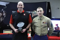 Jason Swift, Shawnee Heights High School Thunderbirds head football coach, stands with Staff Sgt. Skyler Tooker, a Marine Corps Recruiting Station Kansas City, Recruiting Sub-Station Topeka canvassing recruiter, after being presented the Semper Fi Coach Award during the Glazier Clinic at the Westin Crown Center Feb. 6, 2015. Swift was presented the award not just for his on-the-field accomplishments but the way he has influenced players in his community and molded their character on and off the field. Swift has led the Thunderbirds to eight district championships and 10 straight playoff appearances in his 12 years as head coach.