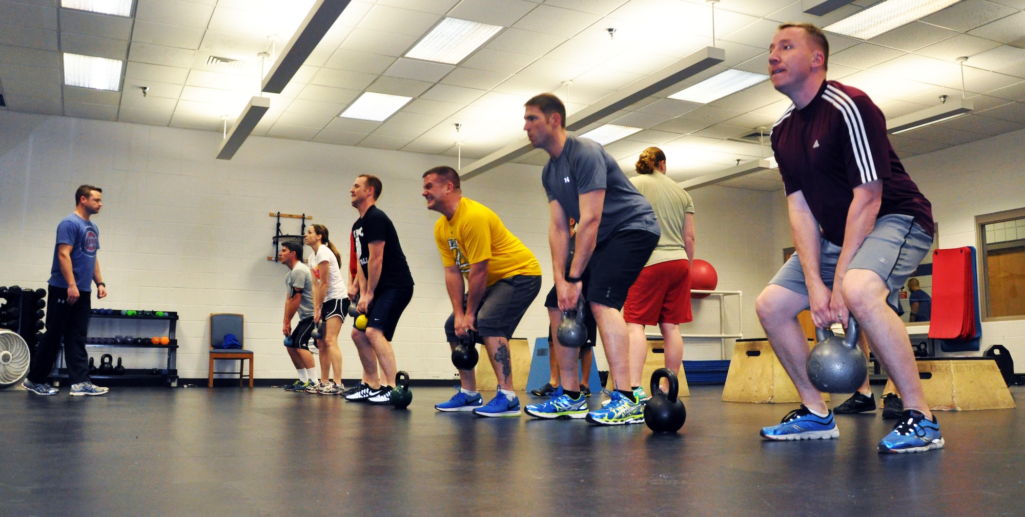 Tech. Sgt. Daniel Mills instructs members of the 18th Air Refueling Squadron as they perform kettlebell squats during a group workout session at the McConnell Air Force Base, Kan., Fitness Center, Feb. 4, 2015. Mills, a refueling boom operator assigned to the 18 ARS, leads daily group workouts for unit members to improve overall fitness and help Airmen stay "fit to fight." (U.S. Air Force photo by Capt. Zach Anderson) 