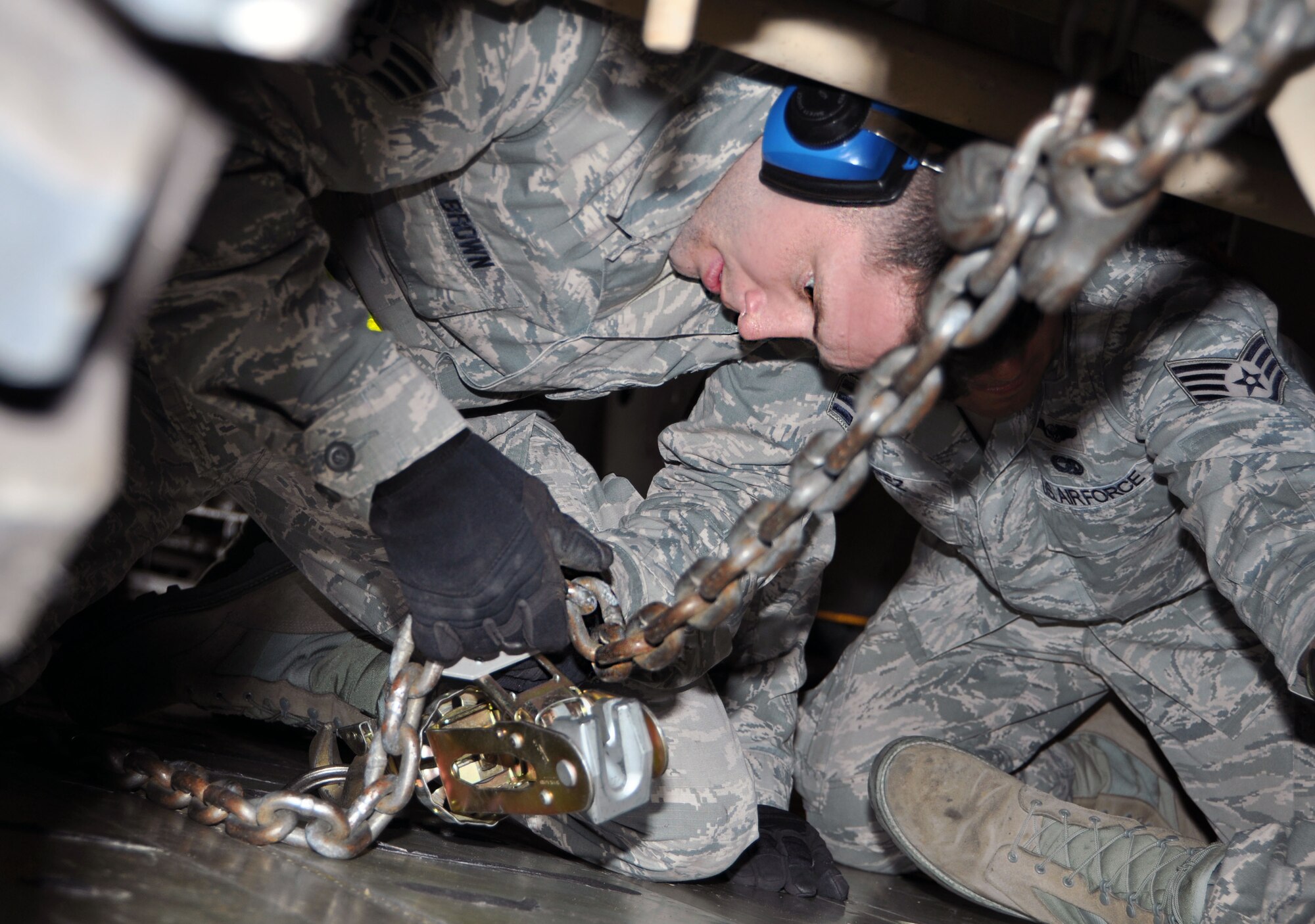Senior Airman Cory Brown, 26th Aerial Port Squadron air transportation specialist, secures a light, medium tactical vehicle into a C-5A Galaxy before takeoff Feb. 7, 2015 on the Joint Base San Antonio-Lackland flight line. Brown and his teammates had to efficiently, upload, tie down and offload a pallet and vehicles into the aircraft as part of the 433rd Airlift Wing’s first "Operation Alamo Stampede competition." The competition pitted two teams of operations, maintenance, and aerial port Airmen, against each other to claim the coveted plaque and bragging rights. (U.S. Air Force photo/Tech. Sgt. Lindsey Maurice)
