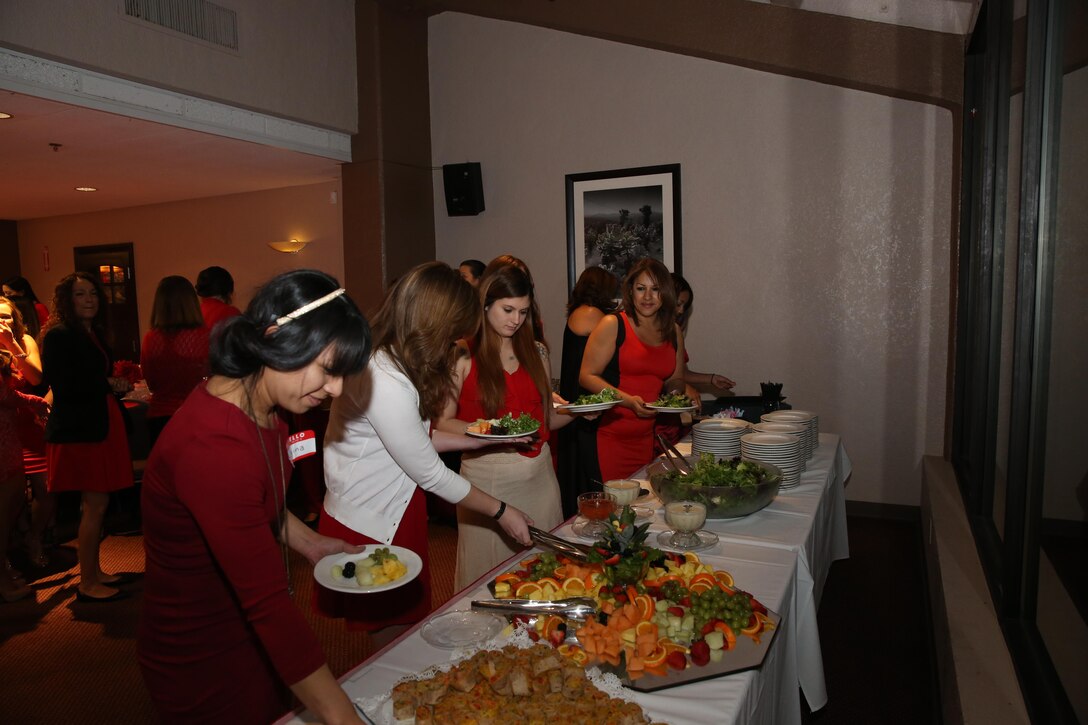 Combat Center patrons help themselves to healthy snack alternatives during The Heart Truth Red Dress Gala and Fashion Show held at the Officers Club, Feb. 5, 2015. The event had approximately 70 women in attendance and is the second time it has been held here. (Official Marine Corps photo by Lance Cpl. Olivia Day/Released)