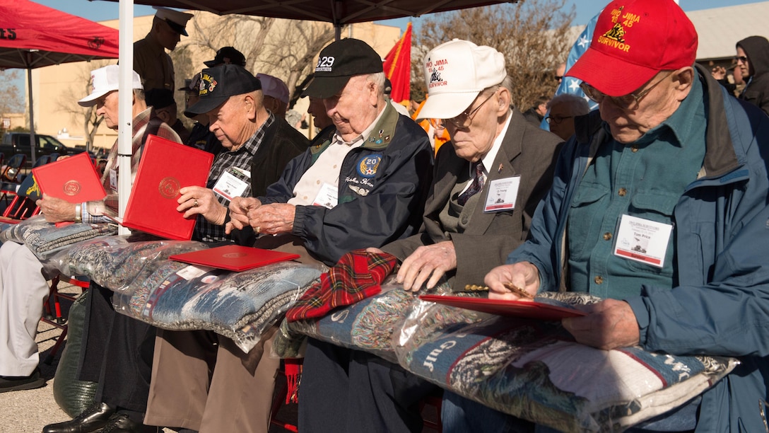 Veterans from the battle for Iwo Jima look at gifts presented to them by the Marine Artillery Detachment at Fort Sill, Oklahoma before a ceremony to honor them and their service February 12, 2015. The Marines of the detachment performed a ceremony, at a barbecue lunch and socialized with the veterans who are gathering this weekend for the last reunion of Iwo Jima veterans.