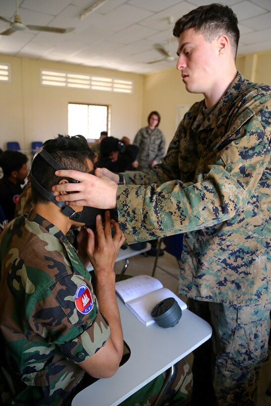 Sgt. Augustin Romero, a Chemical Biological Radiological Nuclear (CBRN) Assessment and Consequence Management (ACM) team Admin and Logistics Non Commissioned Officer in charge with the 11th Marine Expeditionary Unit, helps a member of National Counter Terrorism Special Forces (NCTSF) of Cambodia fit his field protective mask properly as part of a weeklong course teaching the Cambodian service members ACM to further improve their capability to deal with CBRN and Weapons of Mass Destruction (WMD) threats in Phnom Penh, Cambodia, Feb. 09. Now in the last month of a seven-month WESTPAC deployment, the 11th Marine Expeditionary Unit has provided a flexible, sea-based crisis response force to the commanders of U.S. Central Command, 5th Fleet, and 7th Fleet. (U.S. Marine Corps photo by Cpl. Laura Y. Raga/Released)