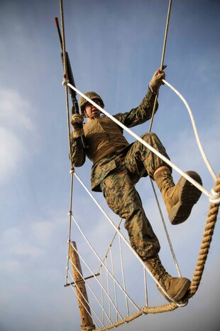 A recruit of Bravo Company, 1st Recruit Training Battalion, walks across a rope bridge during a bayonet assault course at Marine Corps Recruit Depot San Diego, Feb. 2. Drill instructors made sure recruits held their weapons correctly throughout the exercise. Upon completion of the course, recruits conducted pugil sticks matches to further their training in close quarter combat.. 