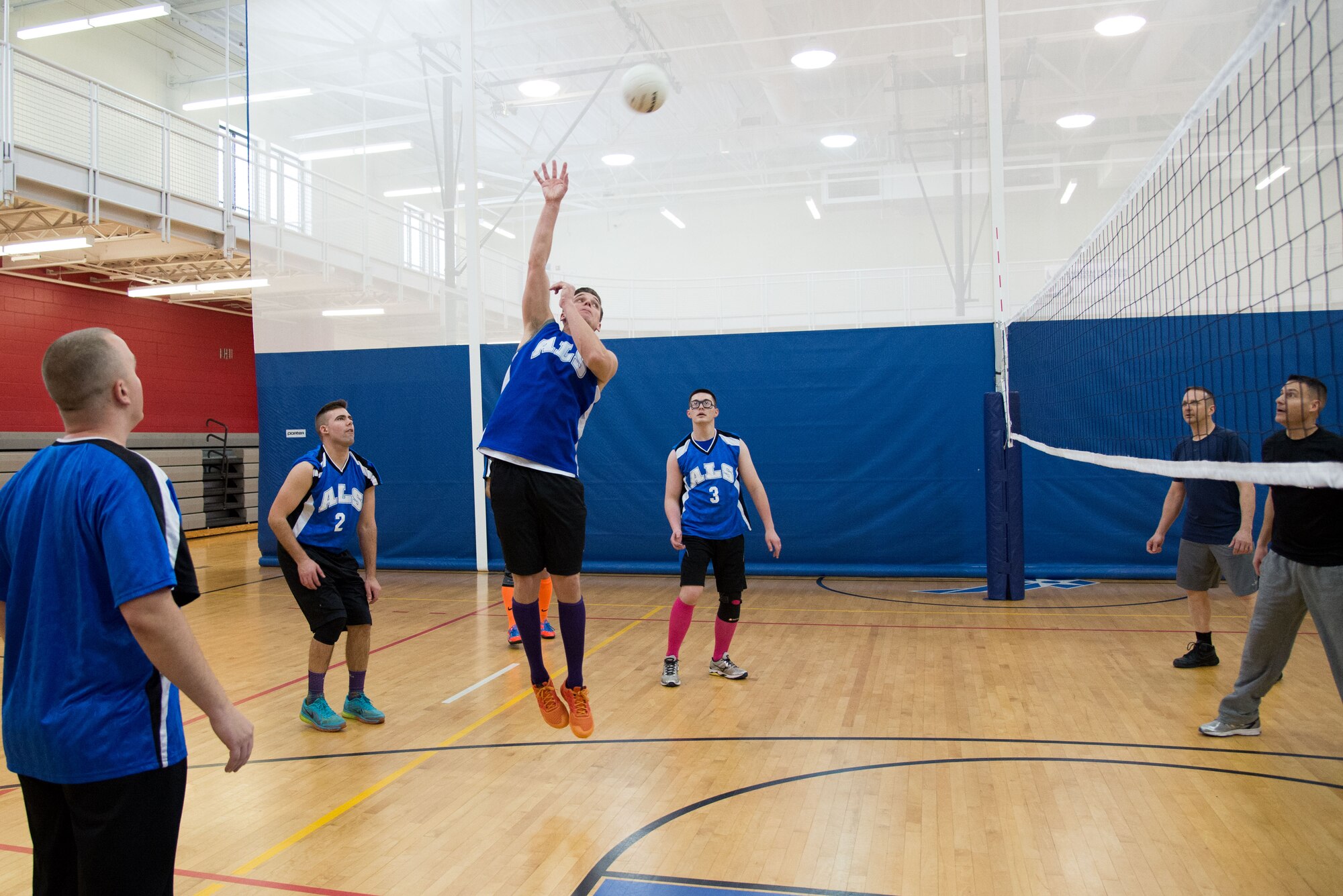 Senior Airman Carl Bennett returns a ball over the net as teammates look on during a volleyball game between Airman Leadership School students and Hanscom Senior NCOs at the Fitness and Sports Center, Feb. 12. The volleyball game is part of ALS heritage and fostering relationships with Senior NCOs and future leaders of the AF. ALS is a five week-long Air Force PME class designed to develop Airmen into effective front-line supervisors. The curriculum focuses on developing leadership abilities as well as effective communication. (U.S. Air Force photo by Mark Herlihy)