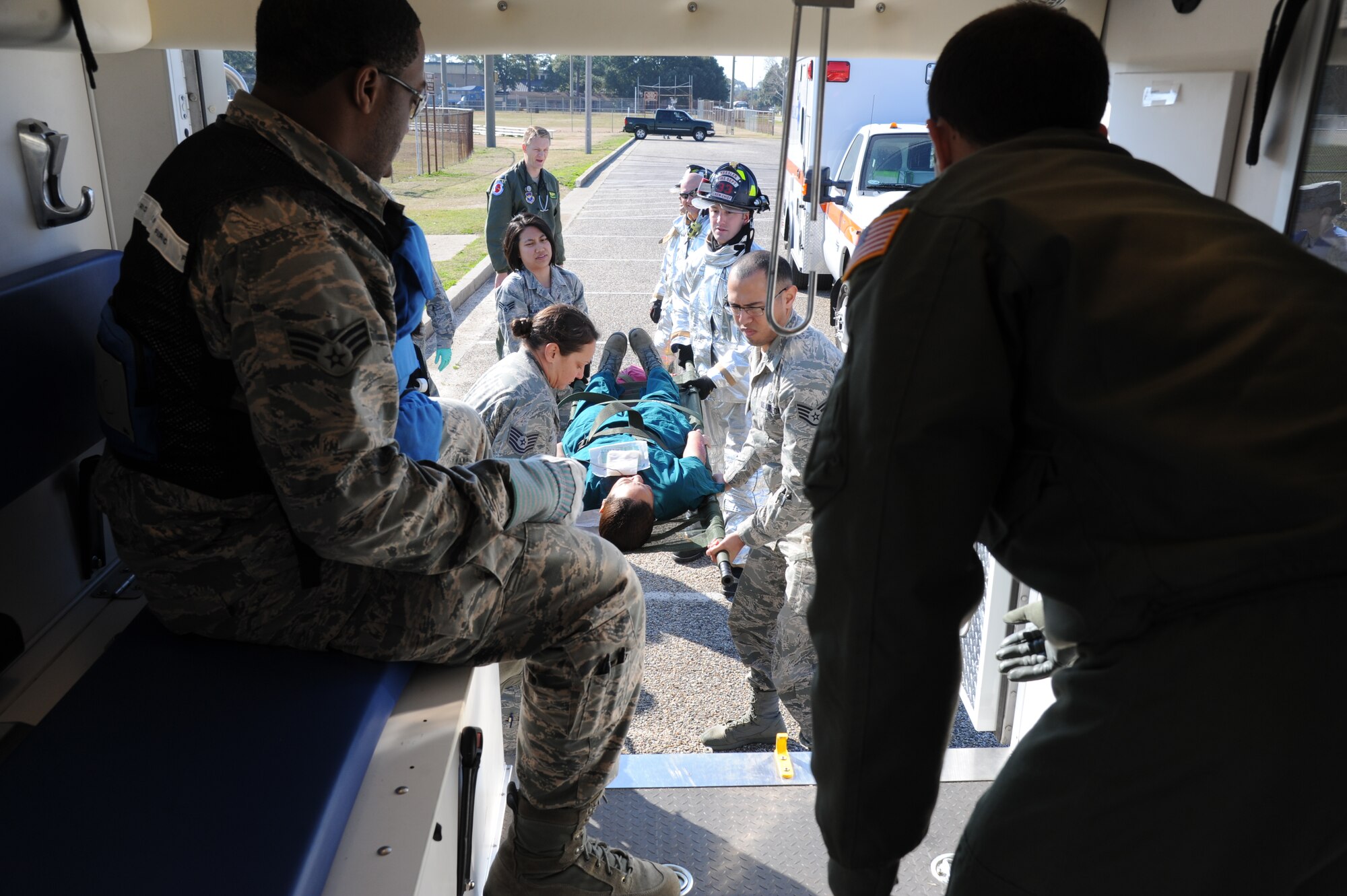 First responders  work together to load a “victim” into an ambulance during a major accident response exercise Feb. 12, 2015, on the flight line, Keesler Air Force Base, Miss.  The MARE simulated a C-130J Hercules aircraft crash on base. The exercise was held to test the readiness of Keesler personnel during a major accident.  (U.S. Air Force photo by Kemberly Groue)